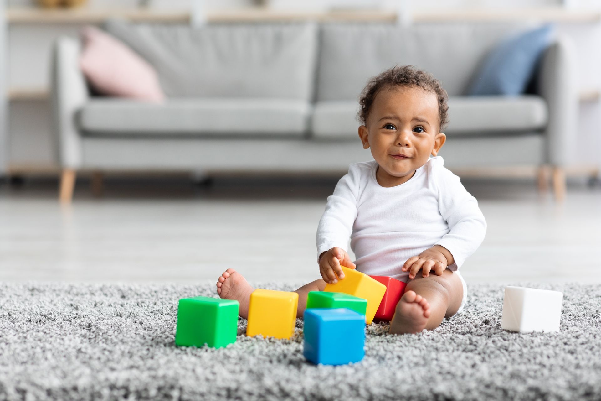 Un bébé sur un tapis avec des cubes à jouer