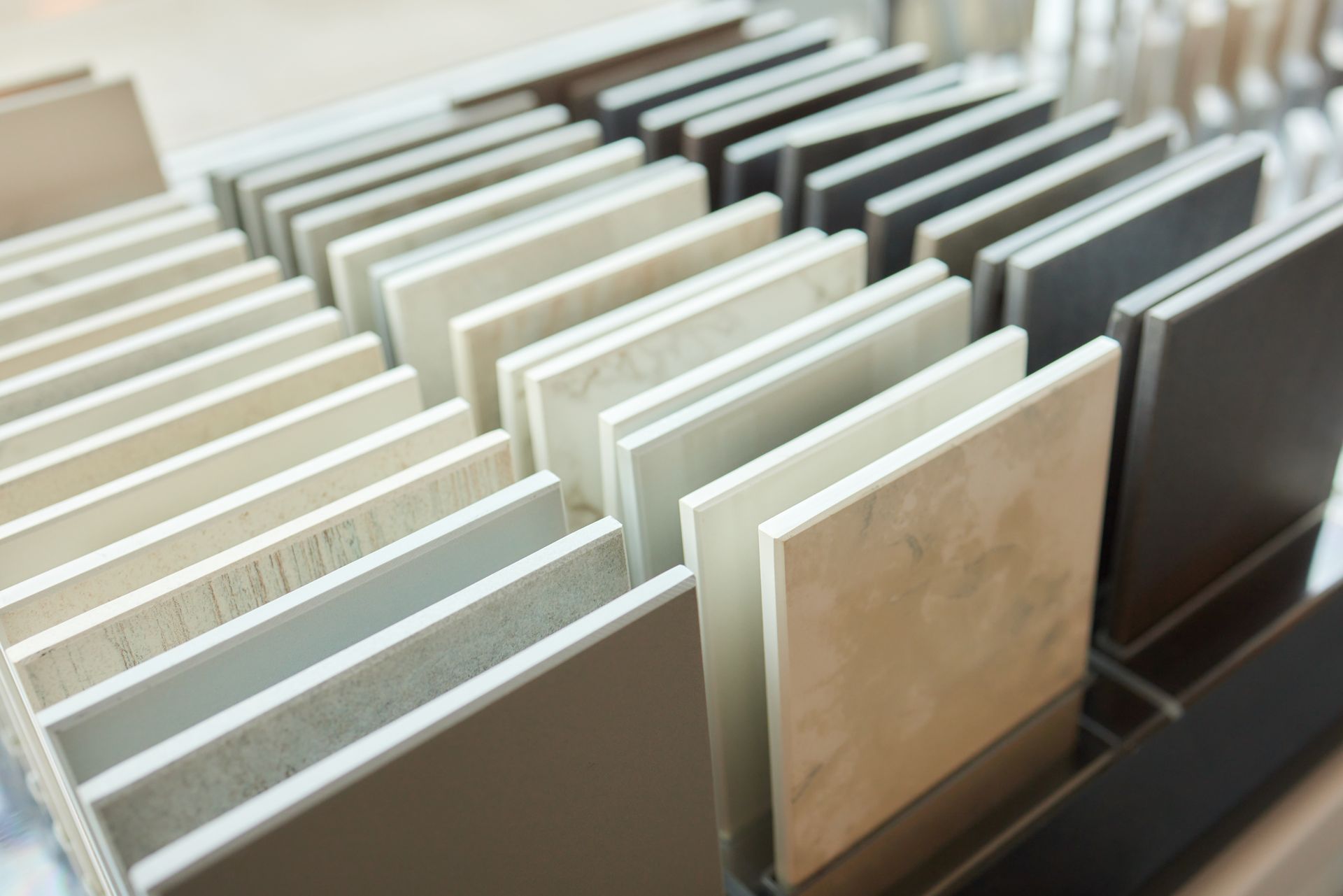 Échantillons de carreaux de différentes couleurs neutres, disposés en rangées.