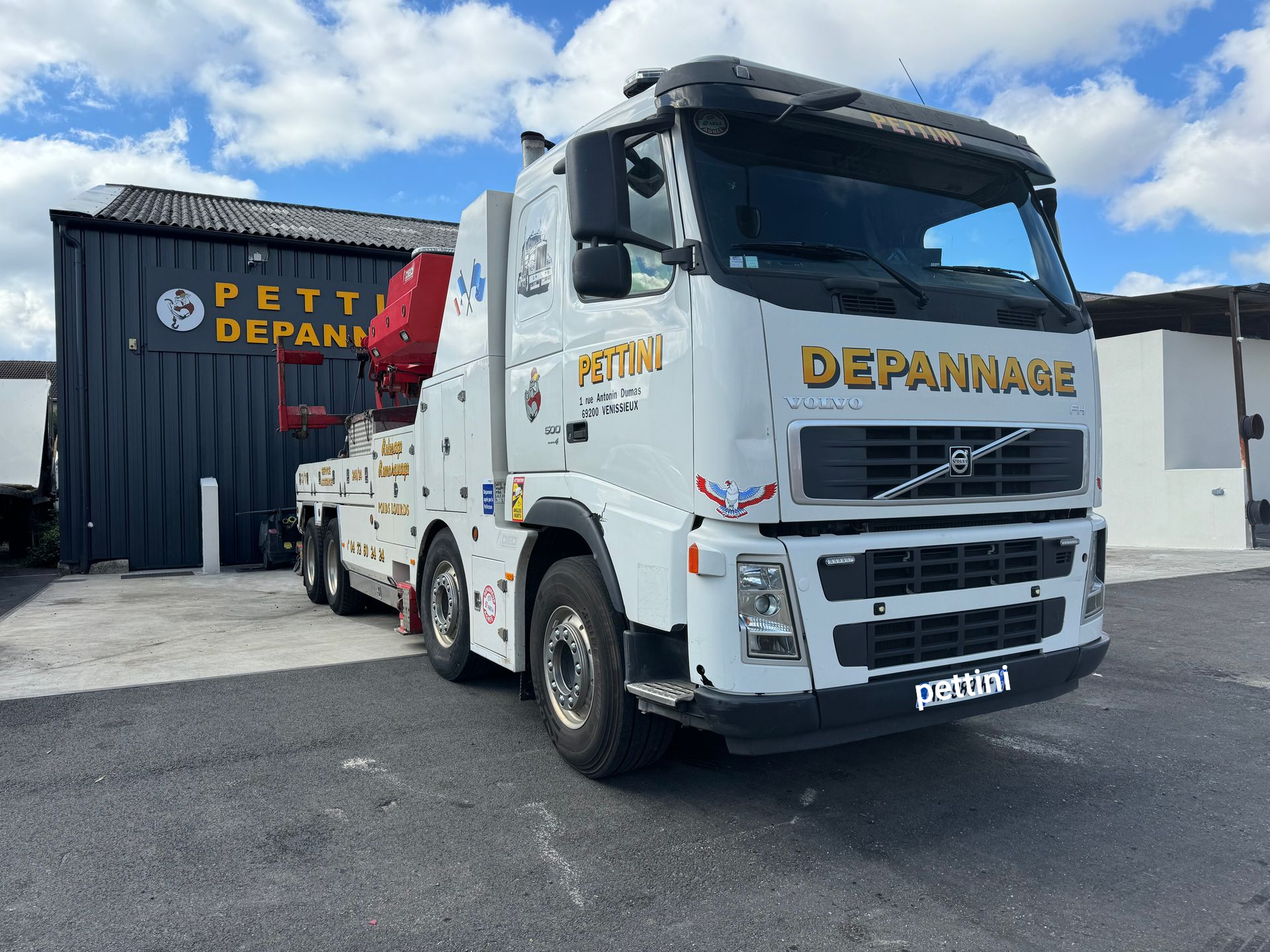 Plusieurs dépanneuses blanches stationnées devant un bâtiment.
