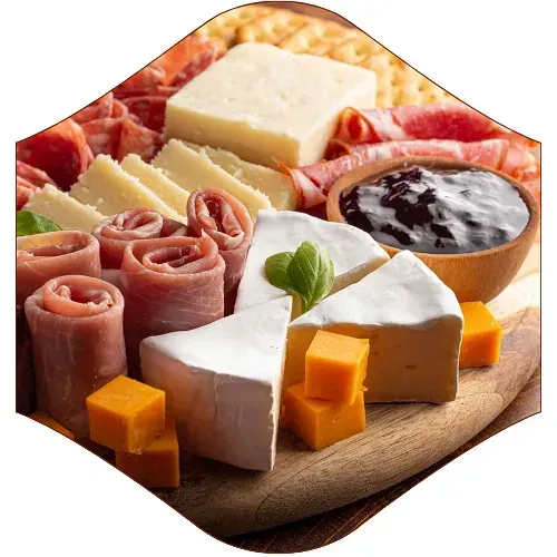 Una tabla de cortar de madera cubierta con una variedad de quesos y carnes.