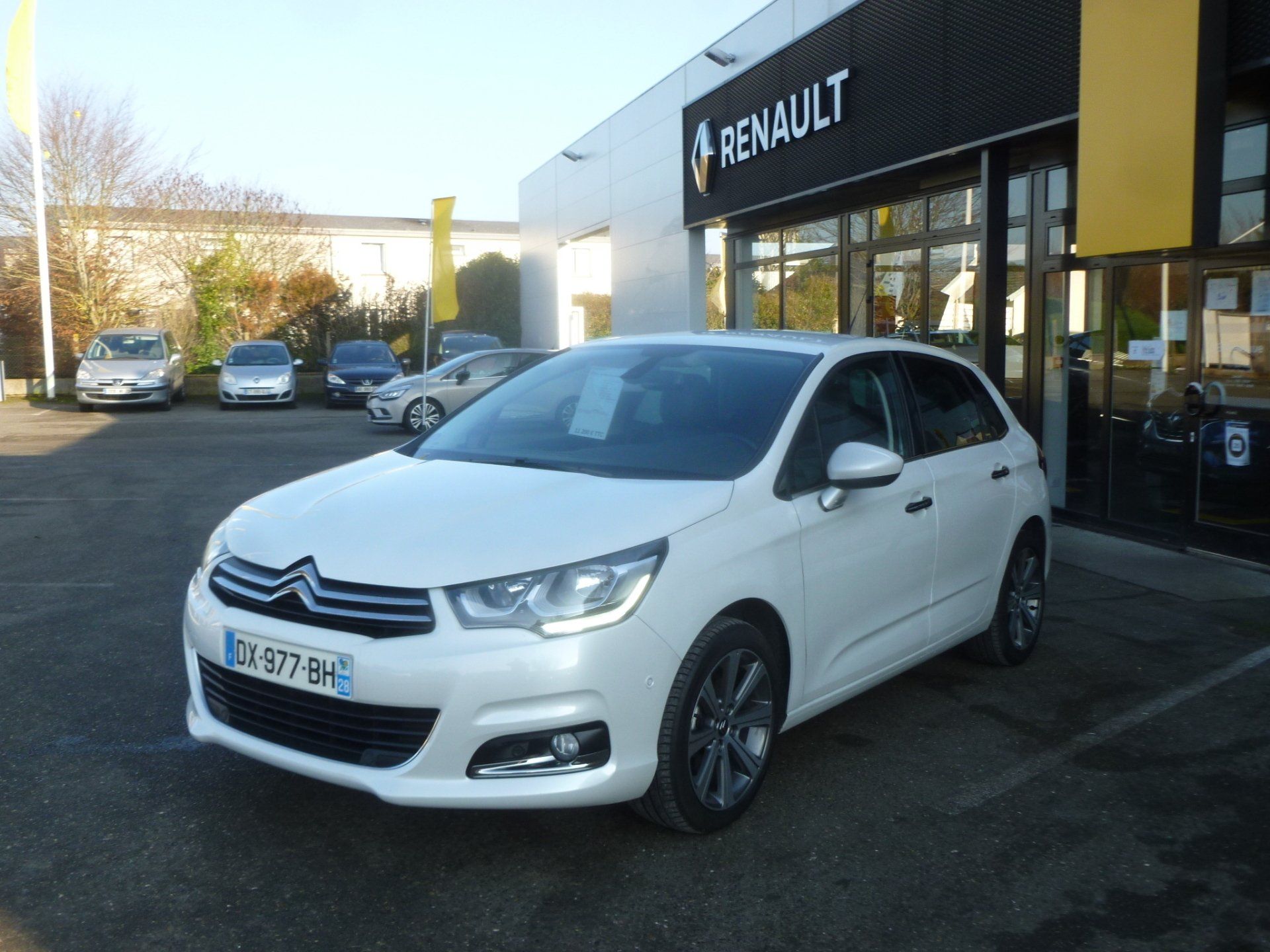 Photo d'une voiture blanche devant le garage automobile