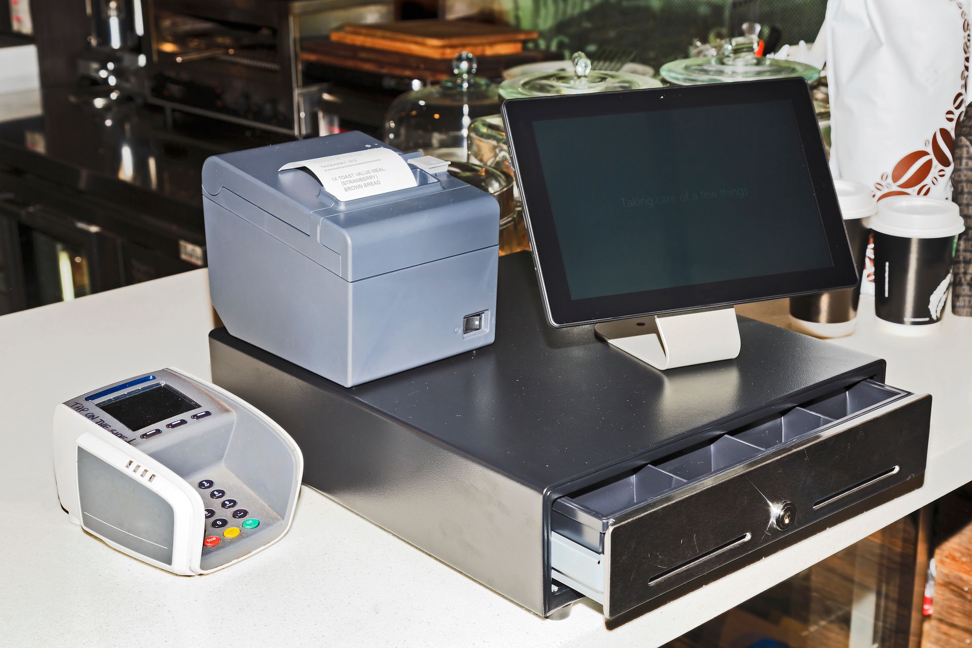 Caisse enregistreuse avec écran tactile, imprimante de reçus, tiroir-caisse et lecteur de cartes.