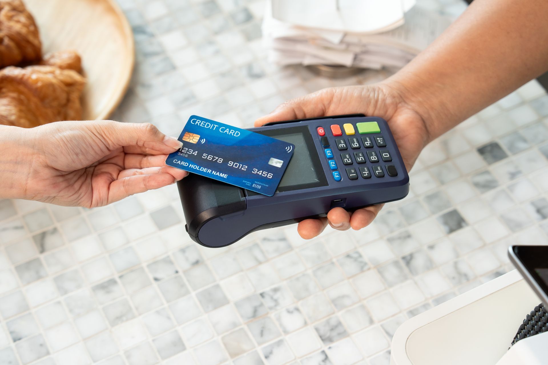 Présenter une carte de crédit bleue pour un paiement sans contact à un lecteur de cartes.