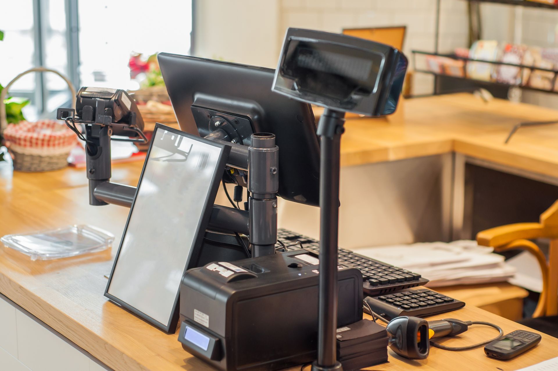 Plan de travail avec écran, tablette, clavier et support pour téléphone dans un espace de travail lumineux.