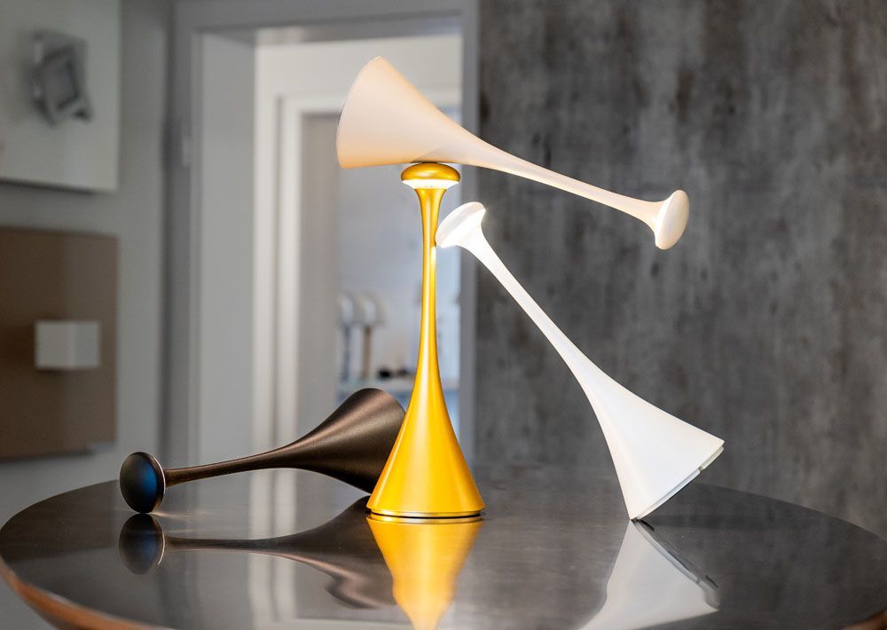 Drei verschiedenfarbige Lampen stehen auf einem Tisch