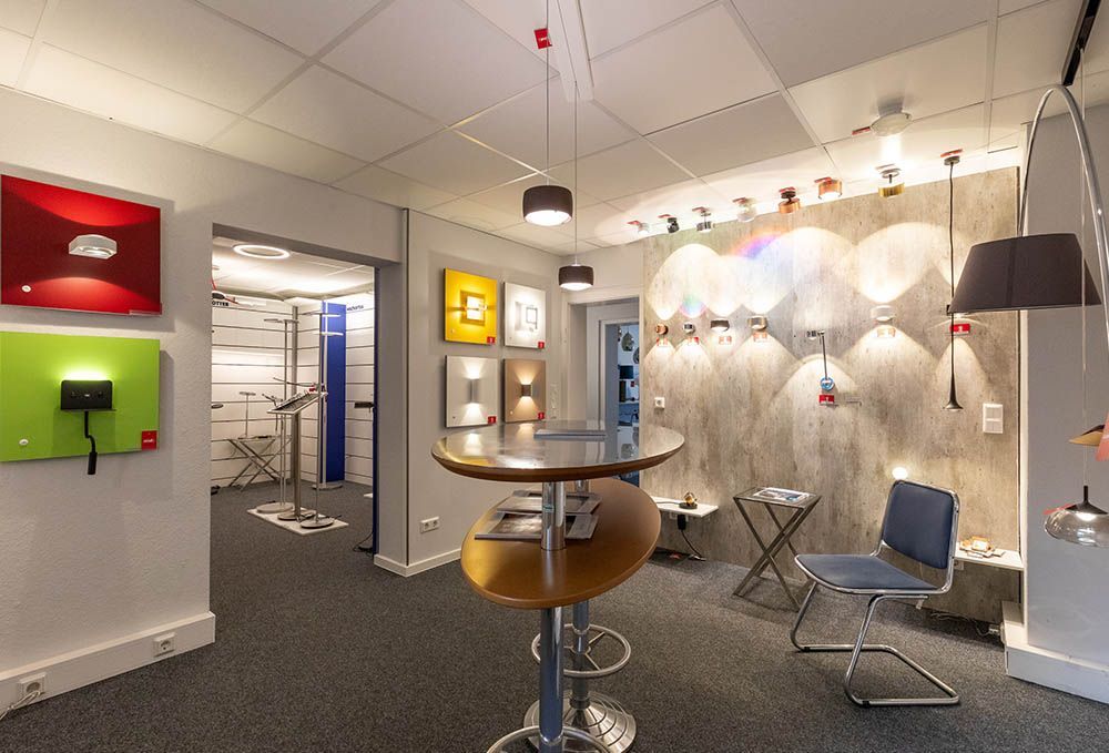 Ein Raum mit einem Tisch und Stühlen und vielen Lichtern an der Wand.