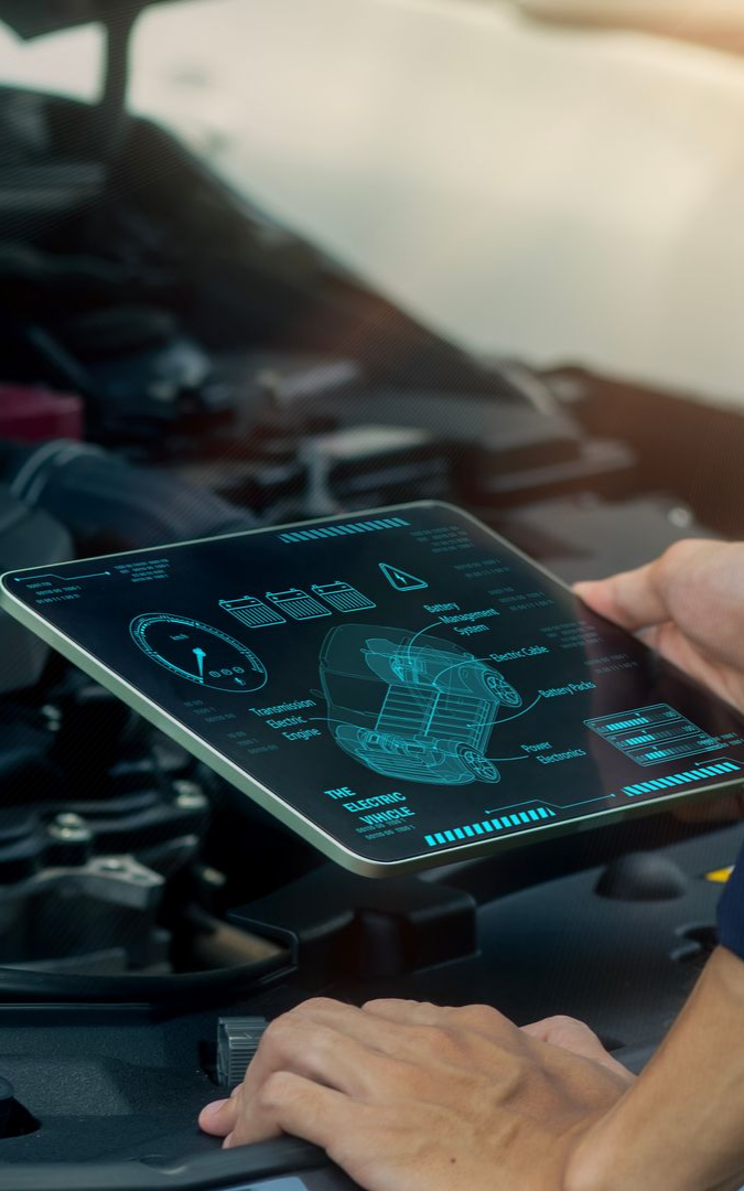 Un mécanicien utilise une tablette pour diagnostiquer un moteur de voiture