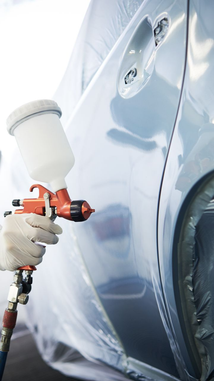 Homme qui peint une voiture en gris
