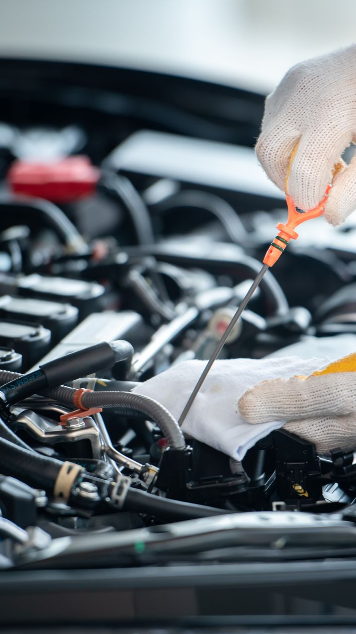 Homme qui prend le niveau d'huile d'une voiture