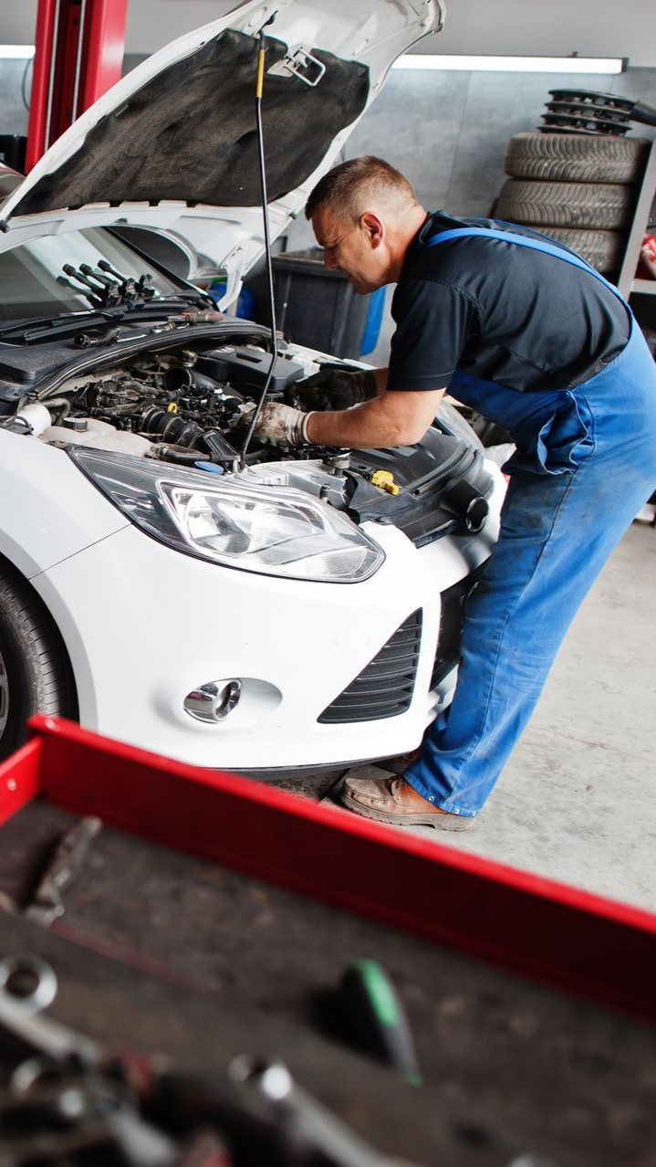 Homme qui répare le moteur d'une voiture 