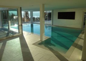 Überdachtes Schwimmbad, halb draussen, halb drinnen