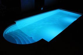 Beleuchtetes Schwimmbecken draussen bei Nacht