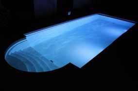 Beleuchtetes Schwimmbecken draussen bei Nacht