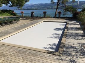 abgedeckter Swimmingpool mit Blick auf den angrenzenden See