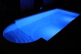 Beleuchtetes Schwimmbecken draussen bei Nacht