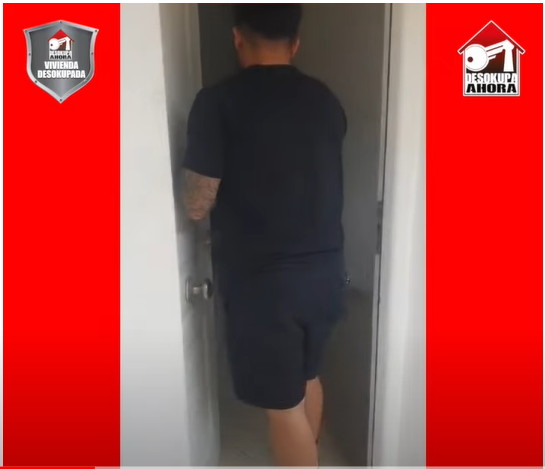 Un hombre con una camisa negra está parado en una puerta.