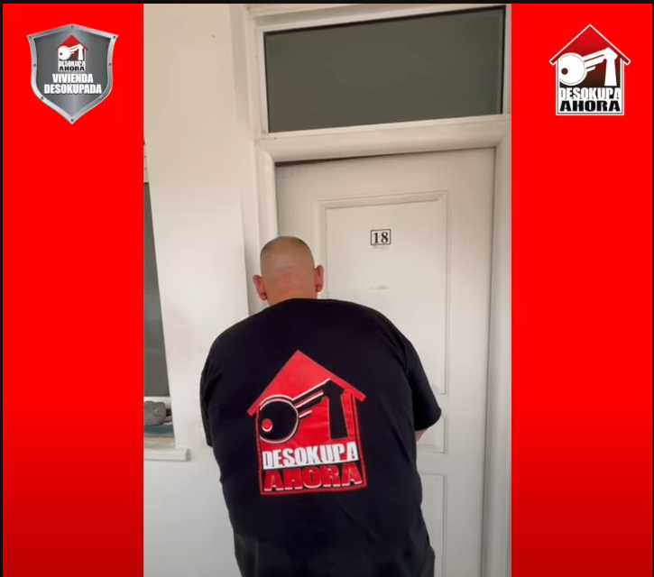 Un hombre que lleva una camisa desokupa se encuentra frente a una puerta.