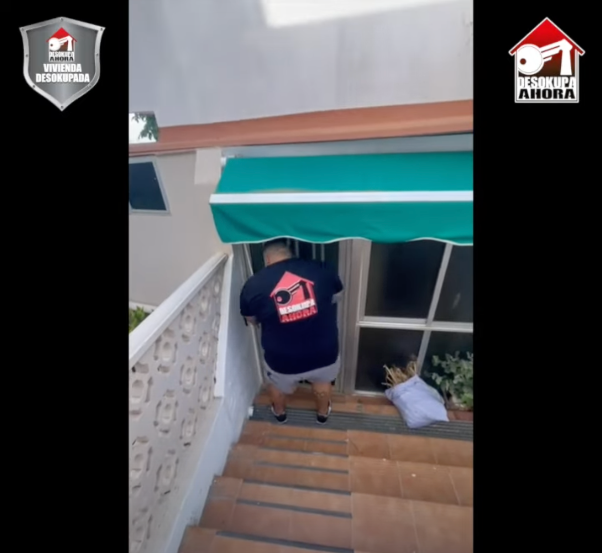 Un hombre con una camisa negra y una casa en la parte de atrás baja las escaleras.
