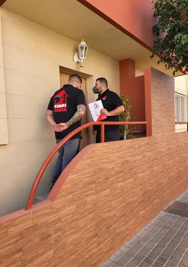 Dos hombres están parados afuera de un edificio hablando entre sí.