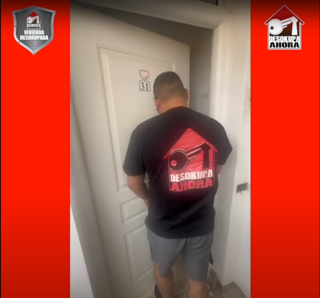 Un hombre parado frente a una puerta con el número 80 en ella.
