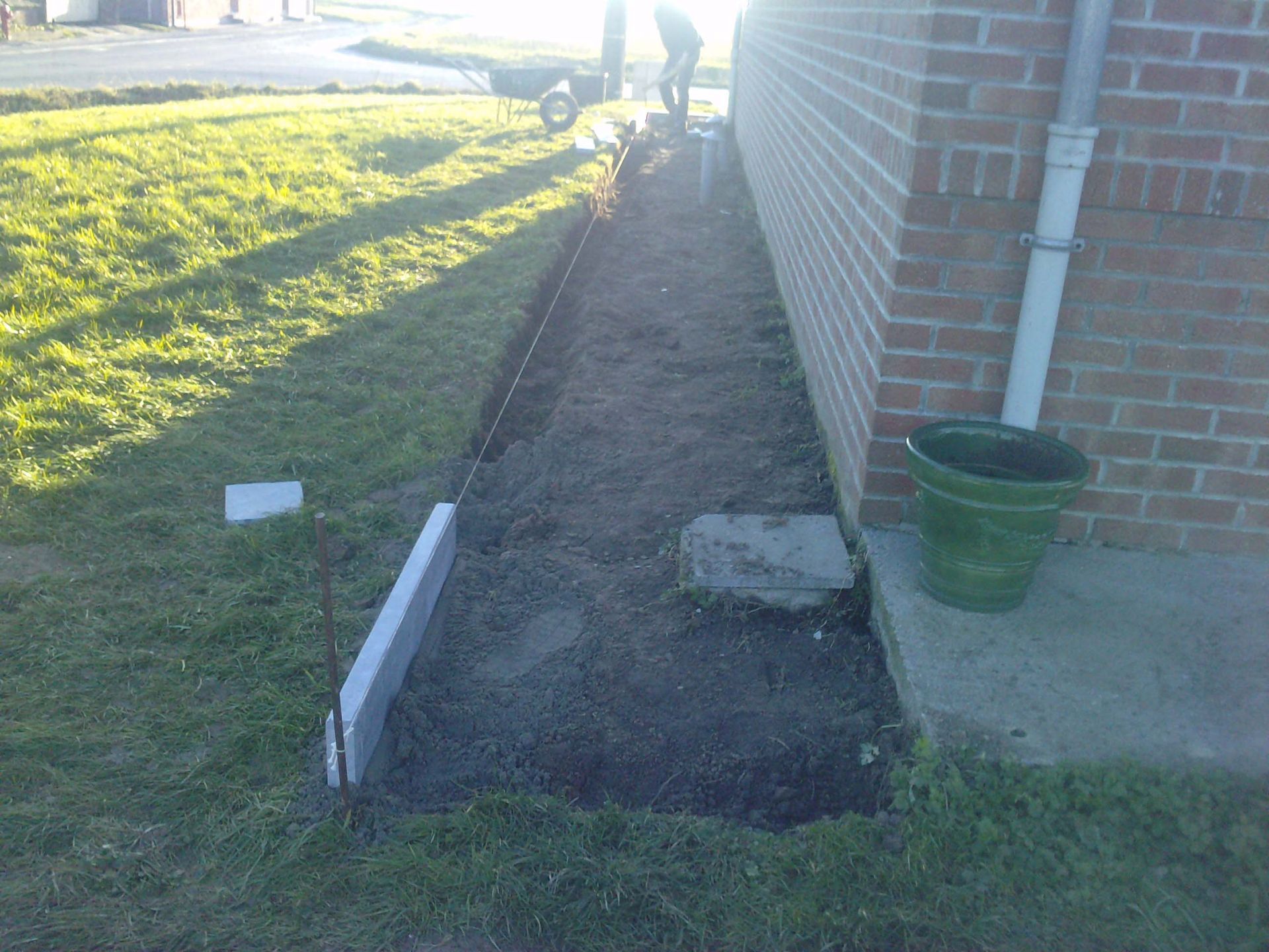 préparation du terrain pour la pose d'une allée le long d'une maison