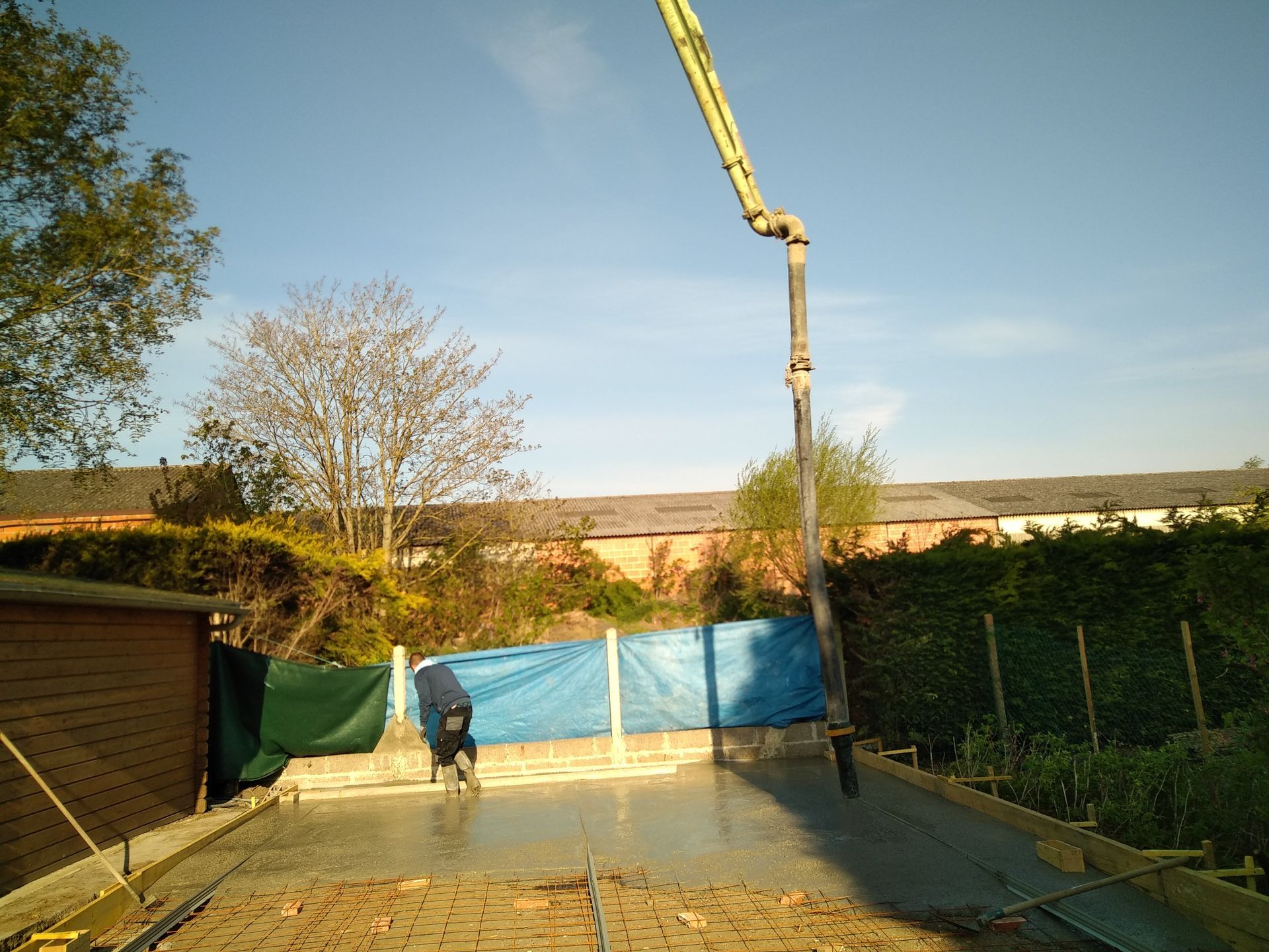 Chape de béton coulée dans un jardin pour la création d'une extension