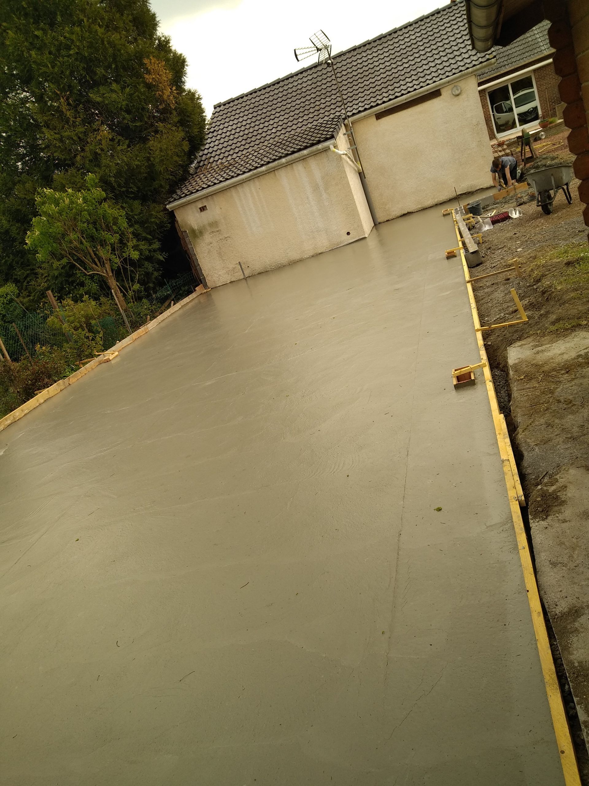 Chape de béton coulée dans un jardin pour la création d'une extension