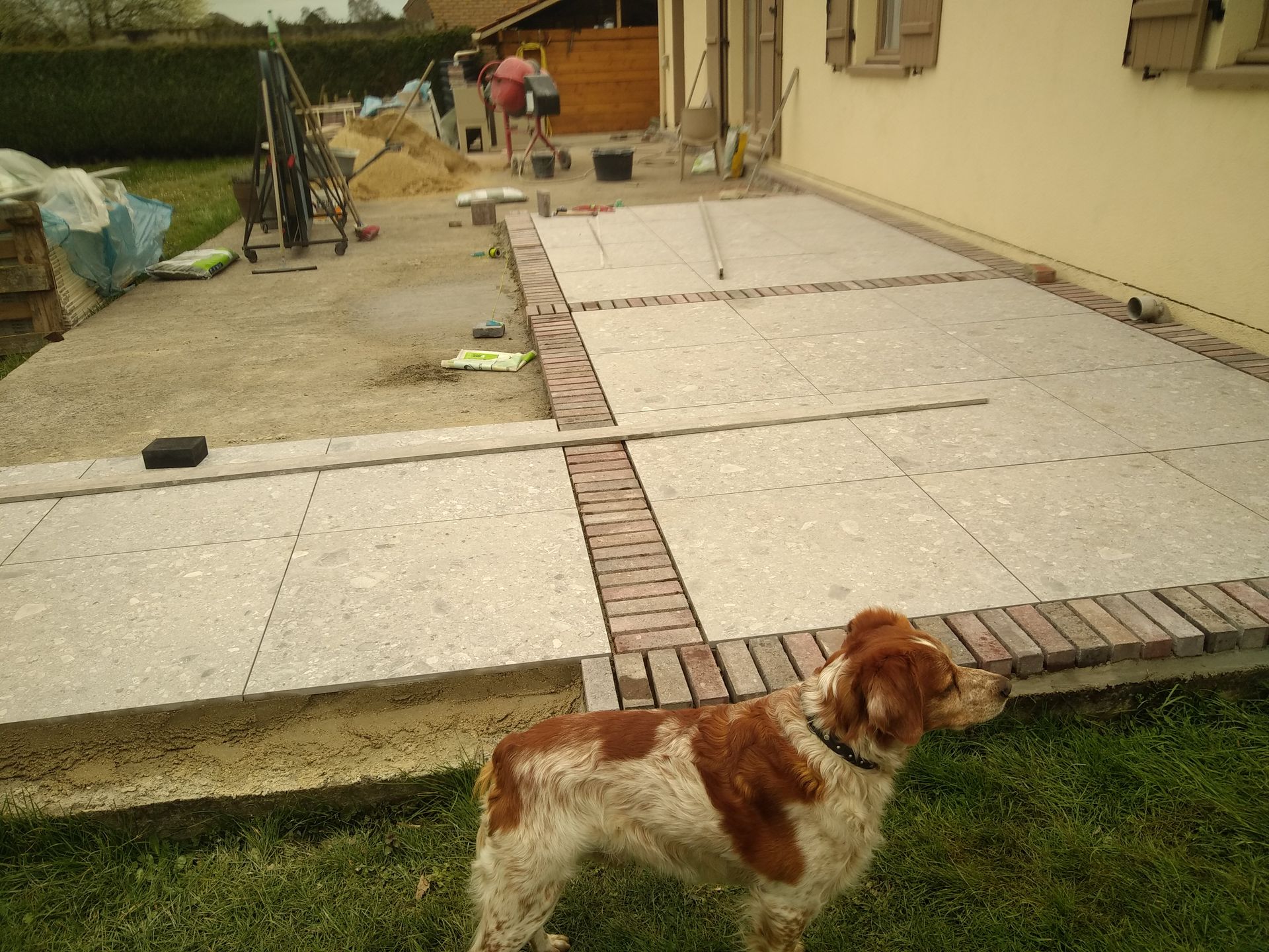 terrasse en chantier en carrelage gris et pavés