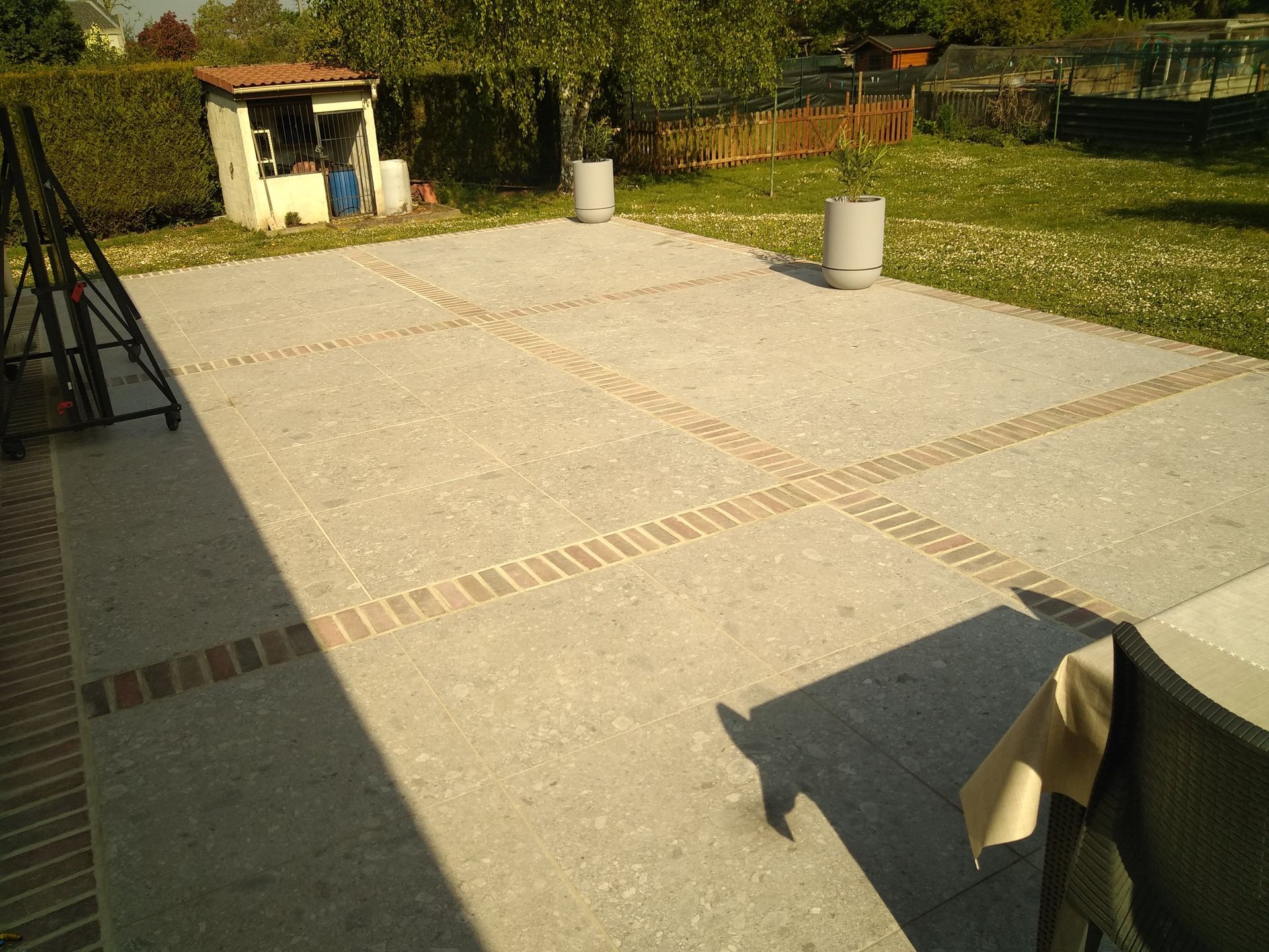 terrasse terminée en carrelage gris et pavés