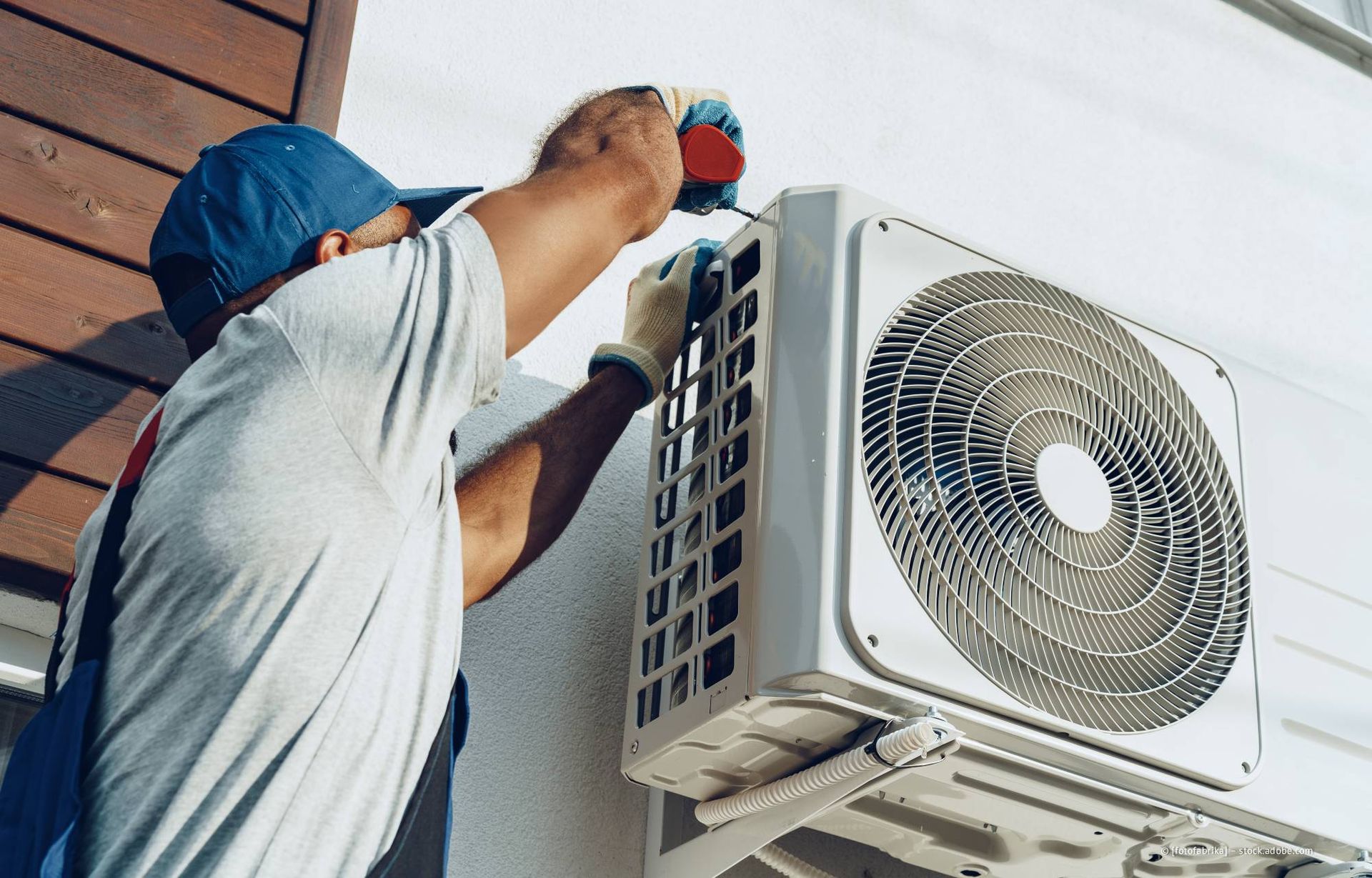 Klimatechniker installiert ein Außengerät einer Klimaanlage.