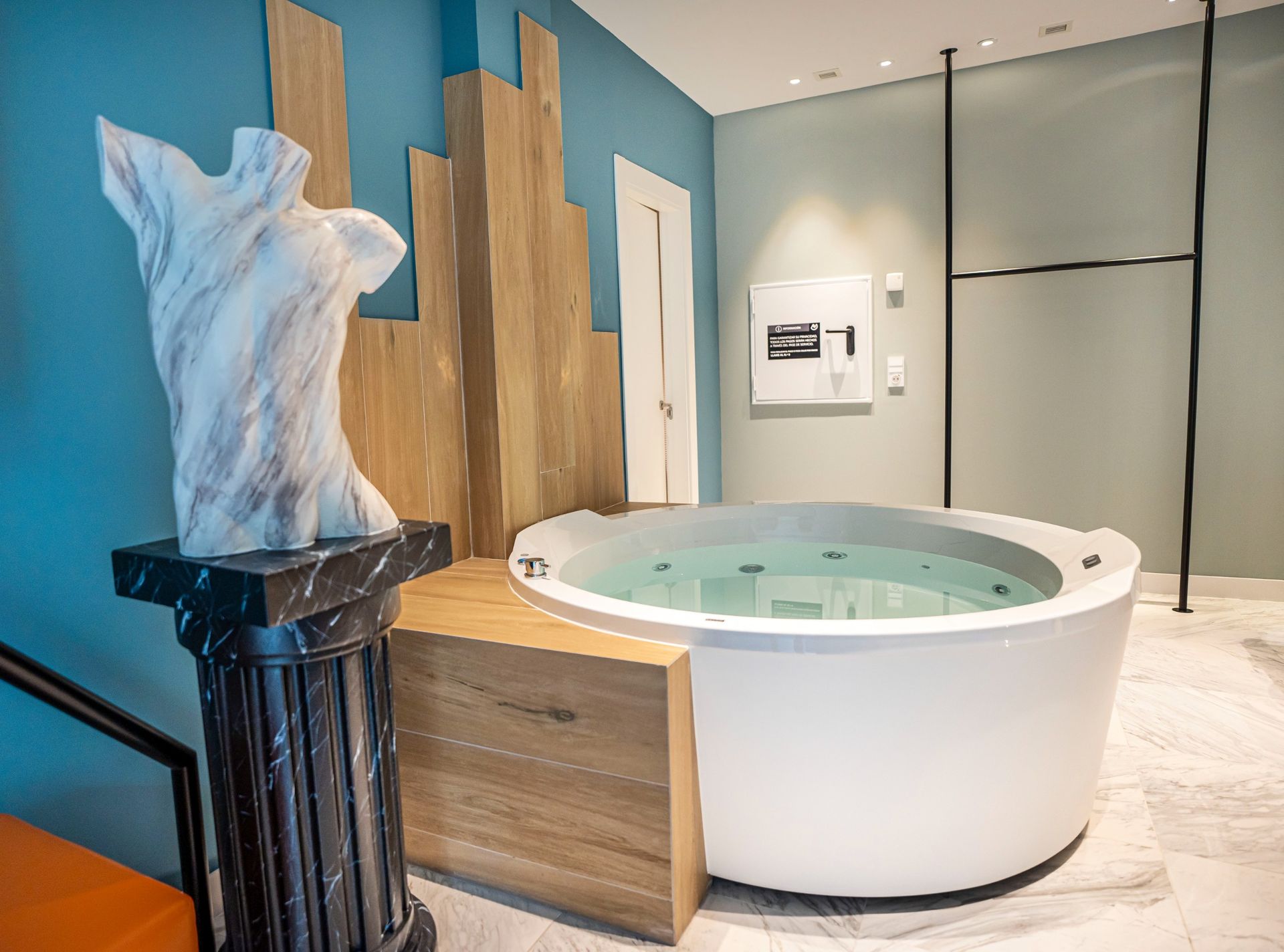 Hay una gran bañera redonda en el medio de la habitación.