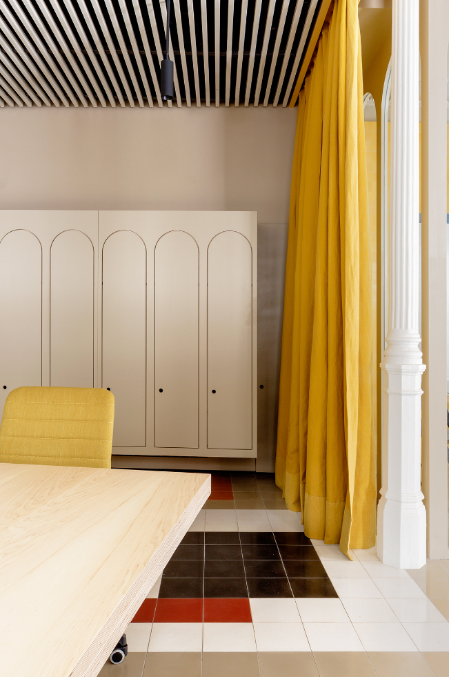 Una habitación con una mesa y sillas y una cortina amarilla.