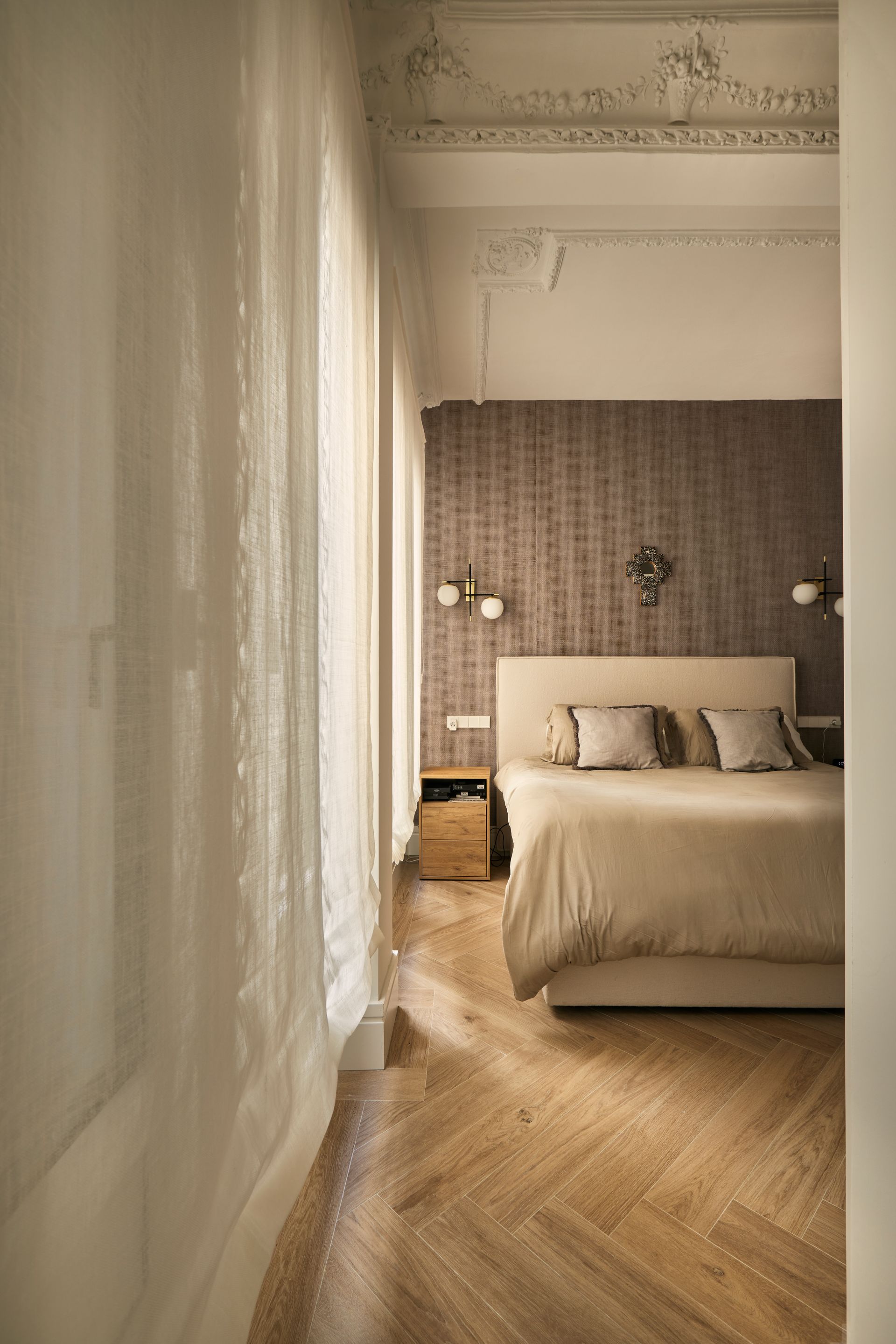 Un dormitorio con una cama grande y suelo de madera.