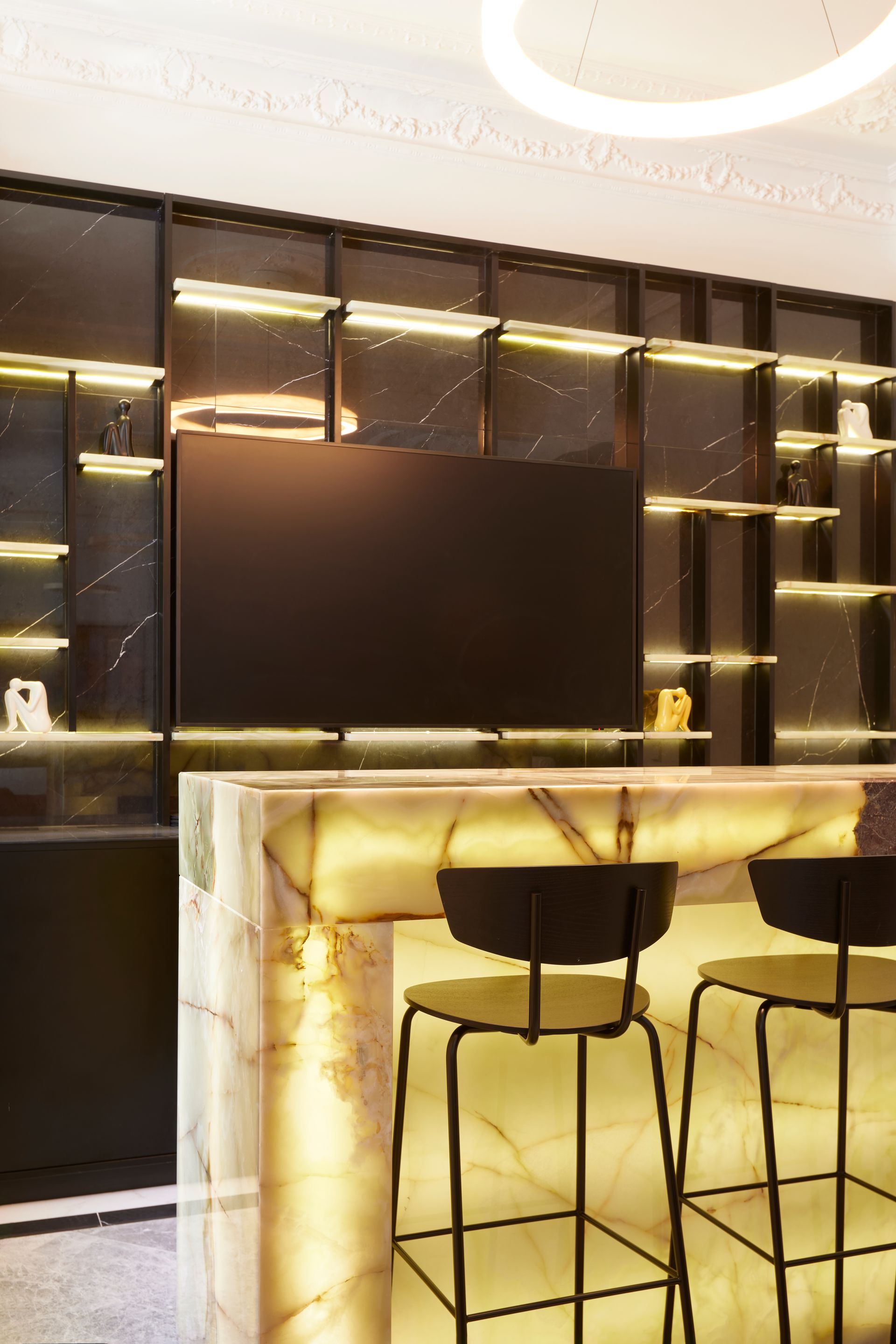 Un bar con taburetes y un televisor de pantalla plana.