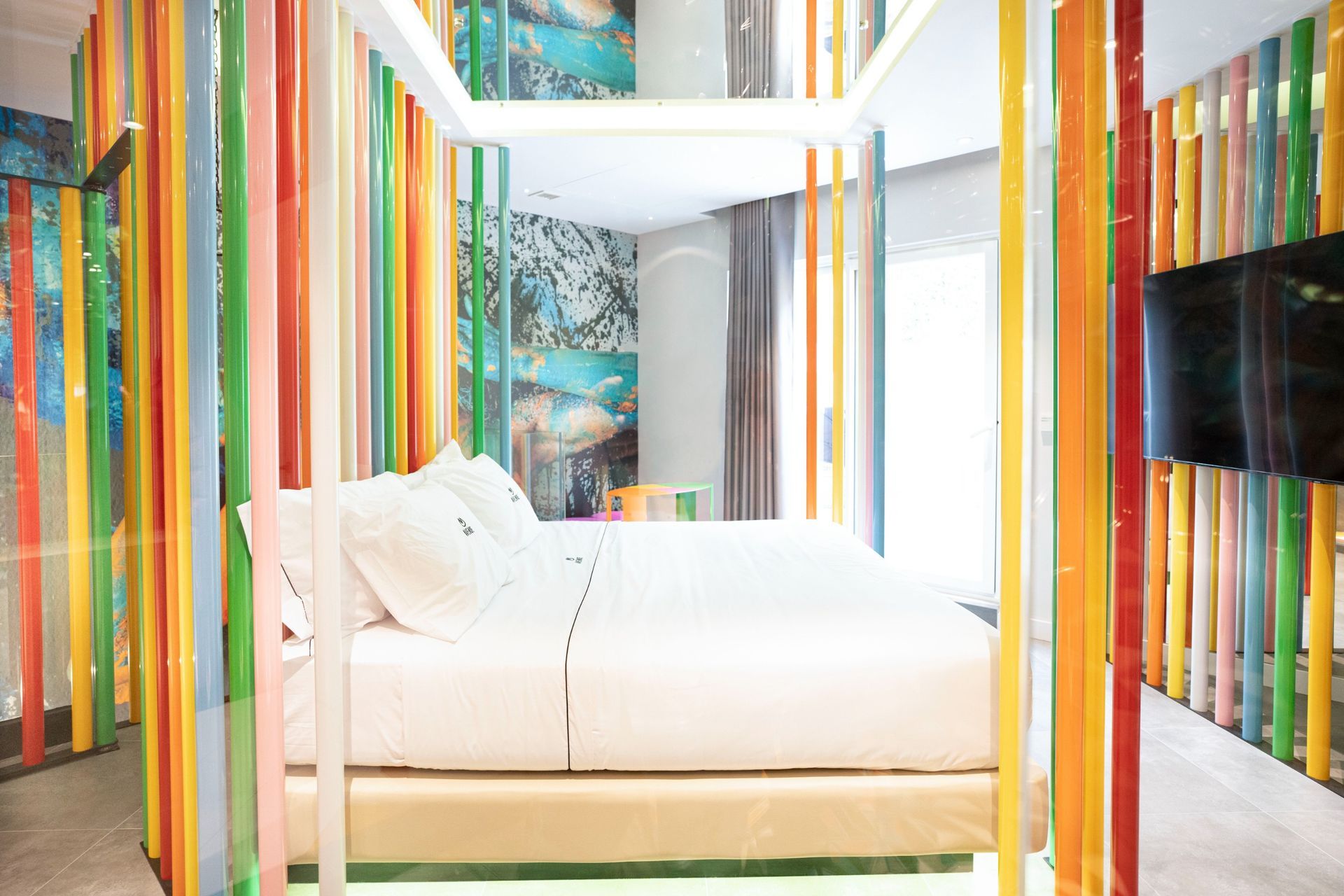 Un dormitorio con cama con dosel y paredes coloridas.