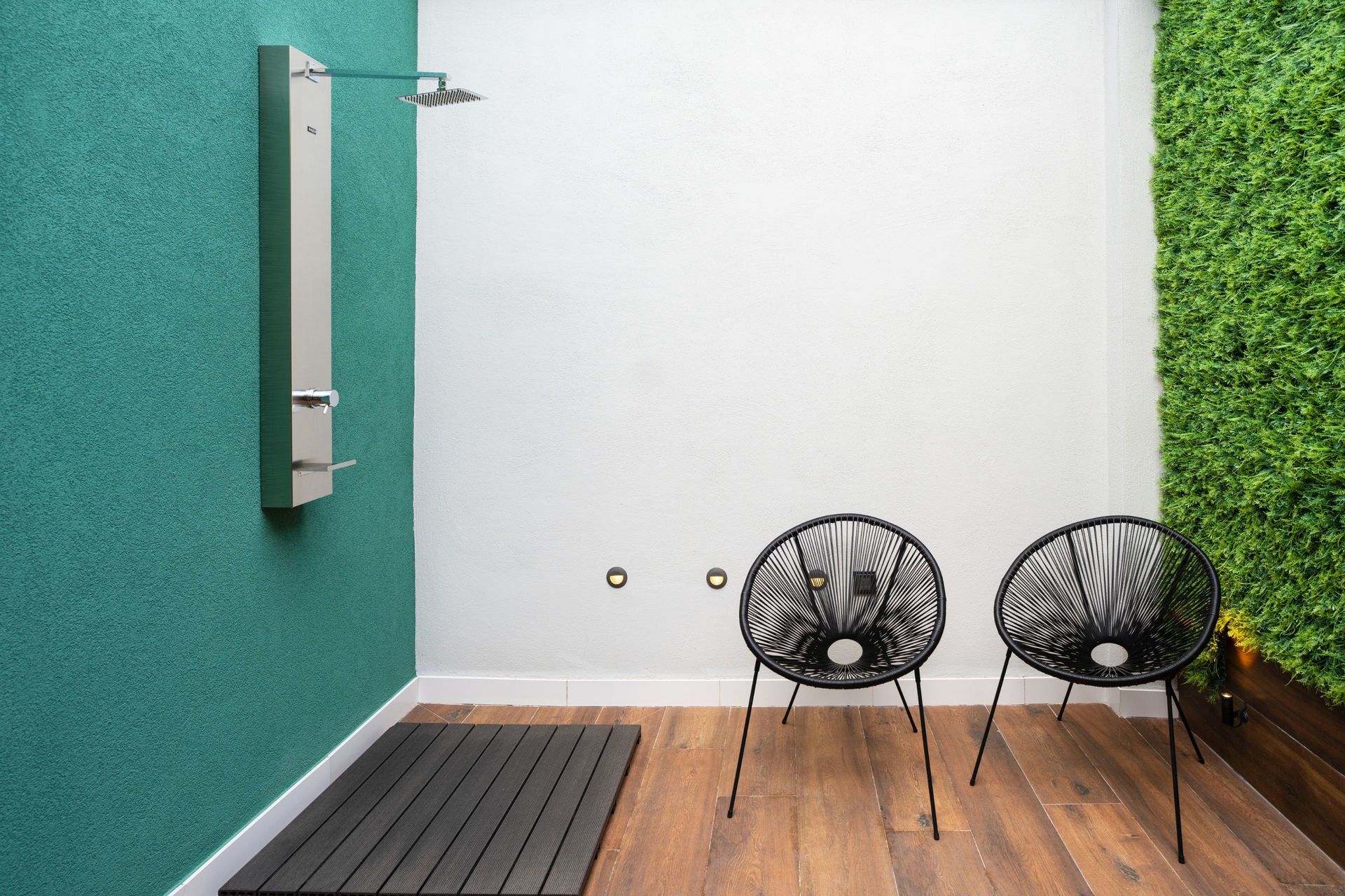 Una habitación con dos sillas y una ducha en la pared.