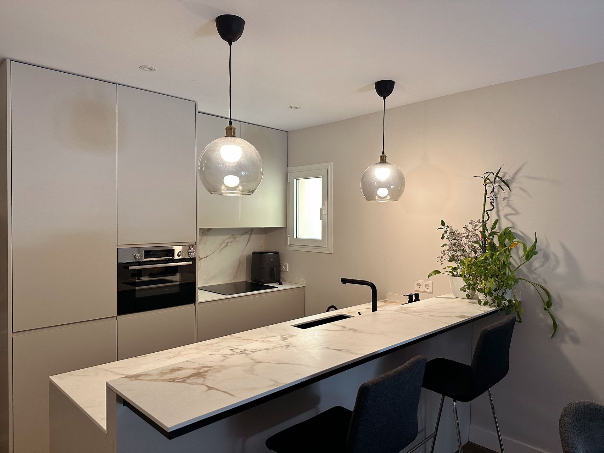 Una cocina con encimera de mármol y taburetes.