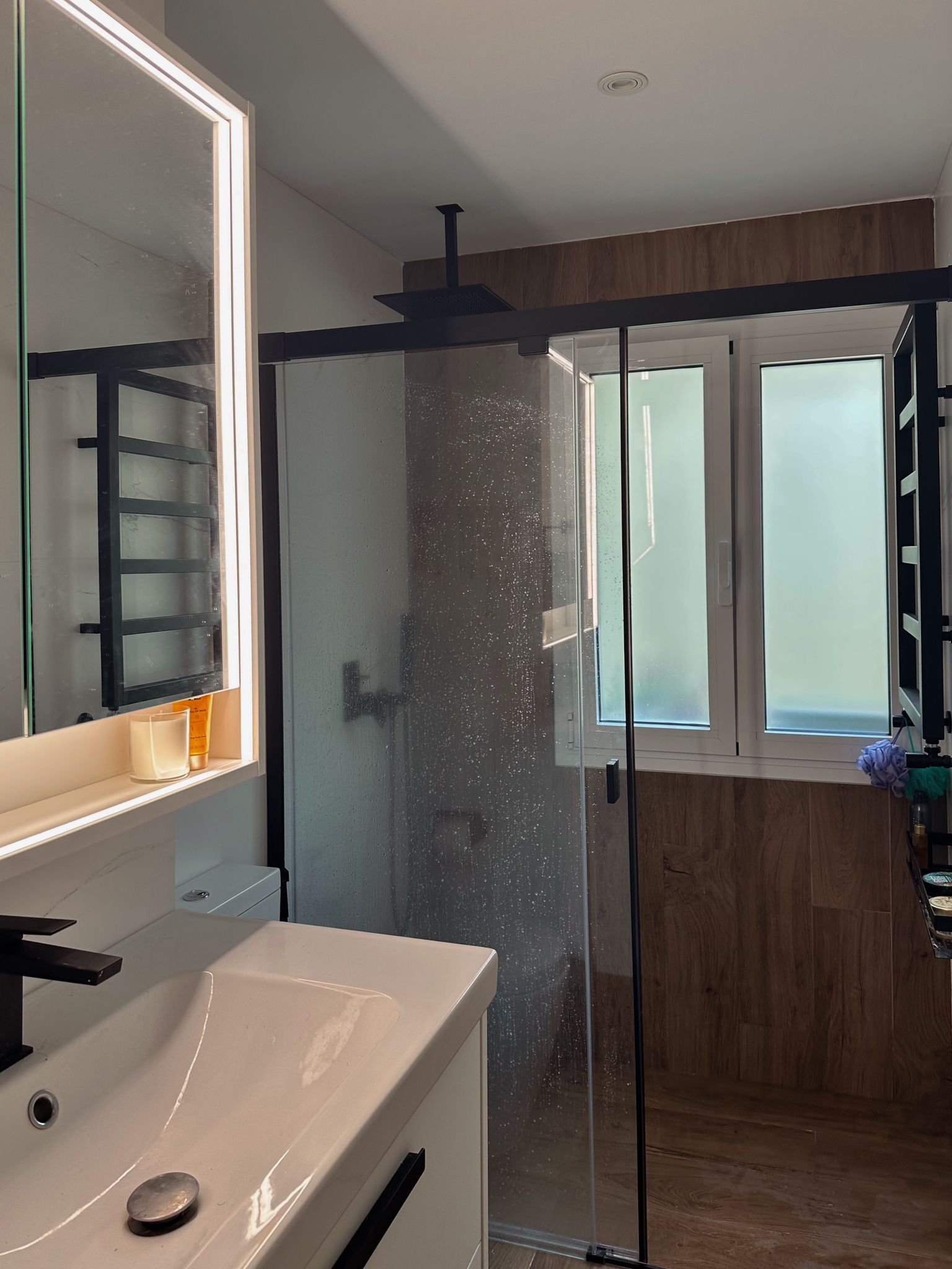 Un baño con lavabo, espejo y ducha.