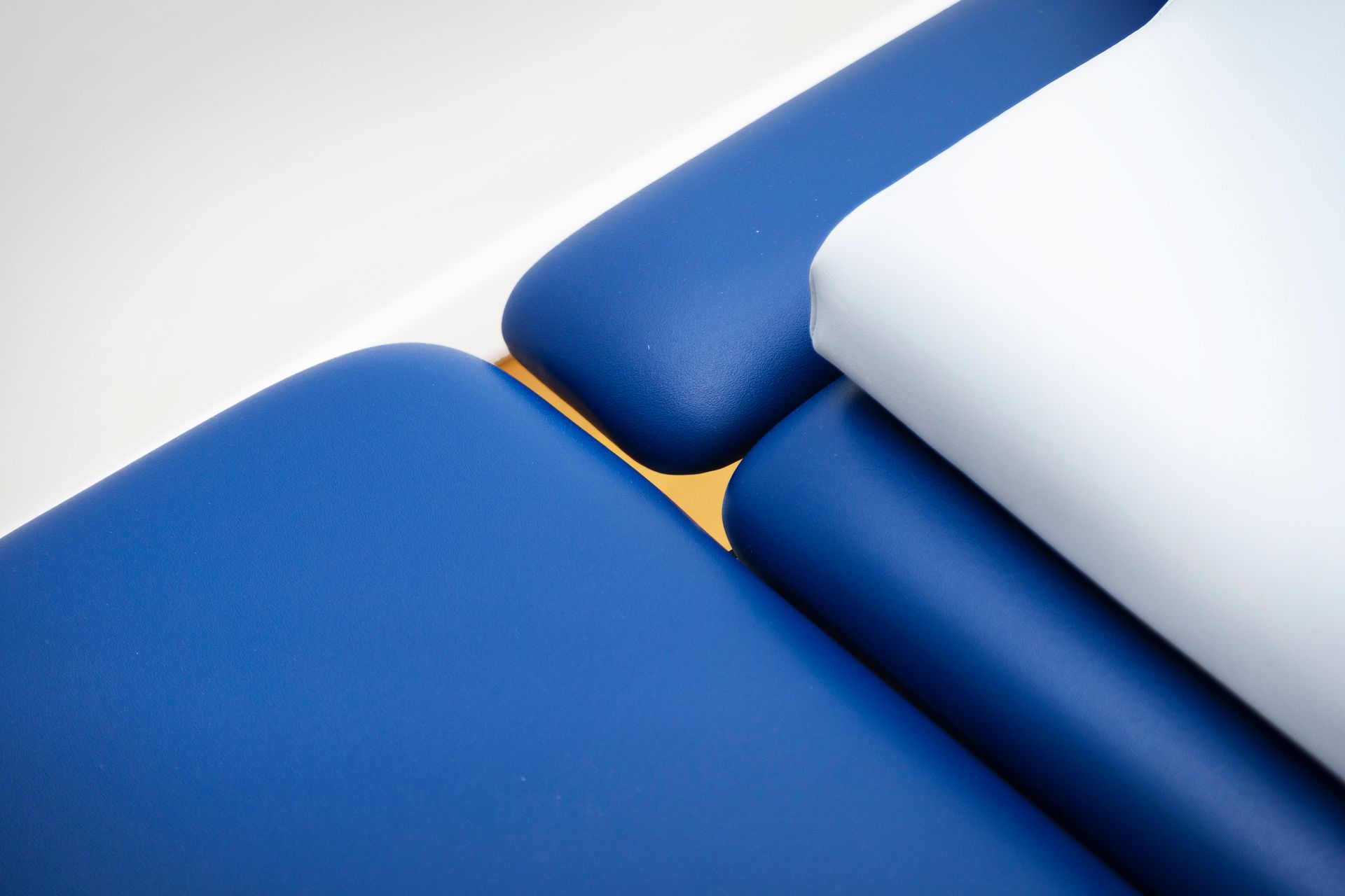 Superfici imbottite blu e bianche disposte insieme, probabilmente parti di un lettino da massaggio.