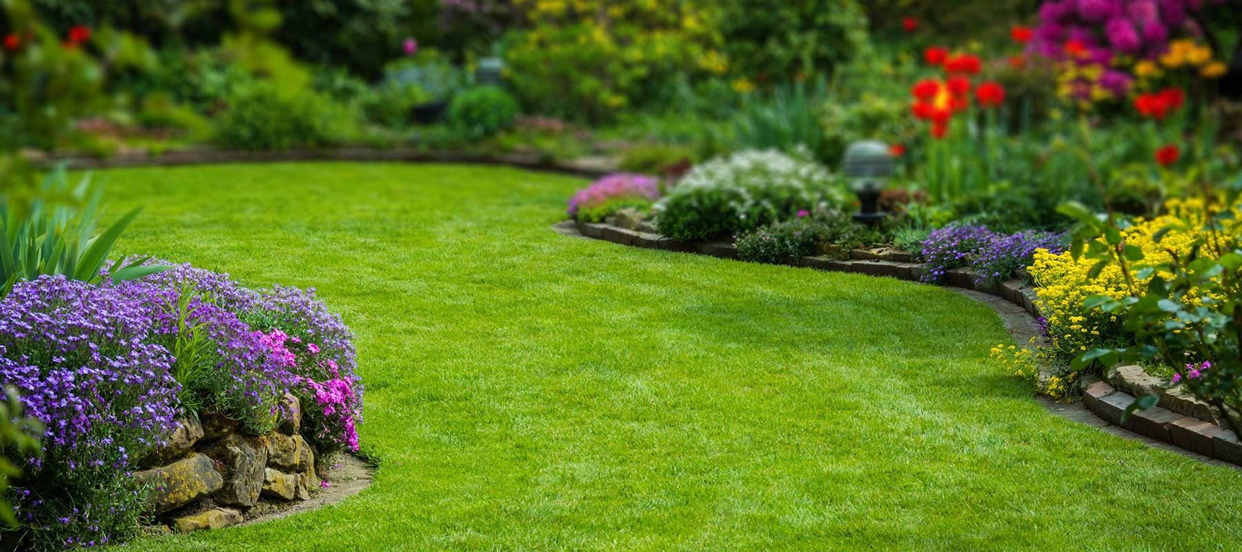 Grand jardin à la pelouse bien entretenue et aux multiples fleurs