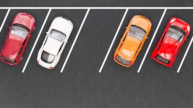 Places de parking en épi et voitures garées