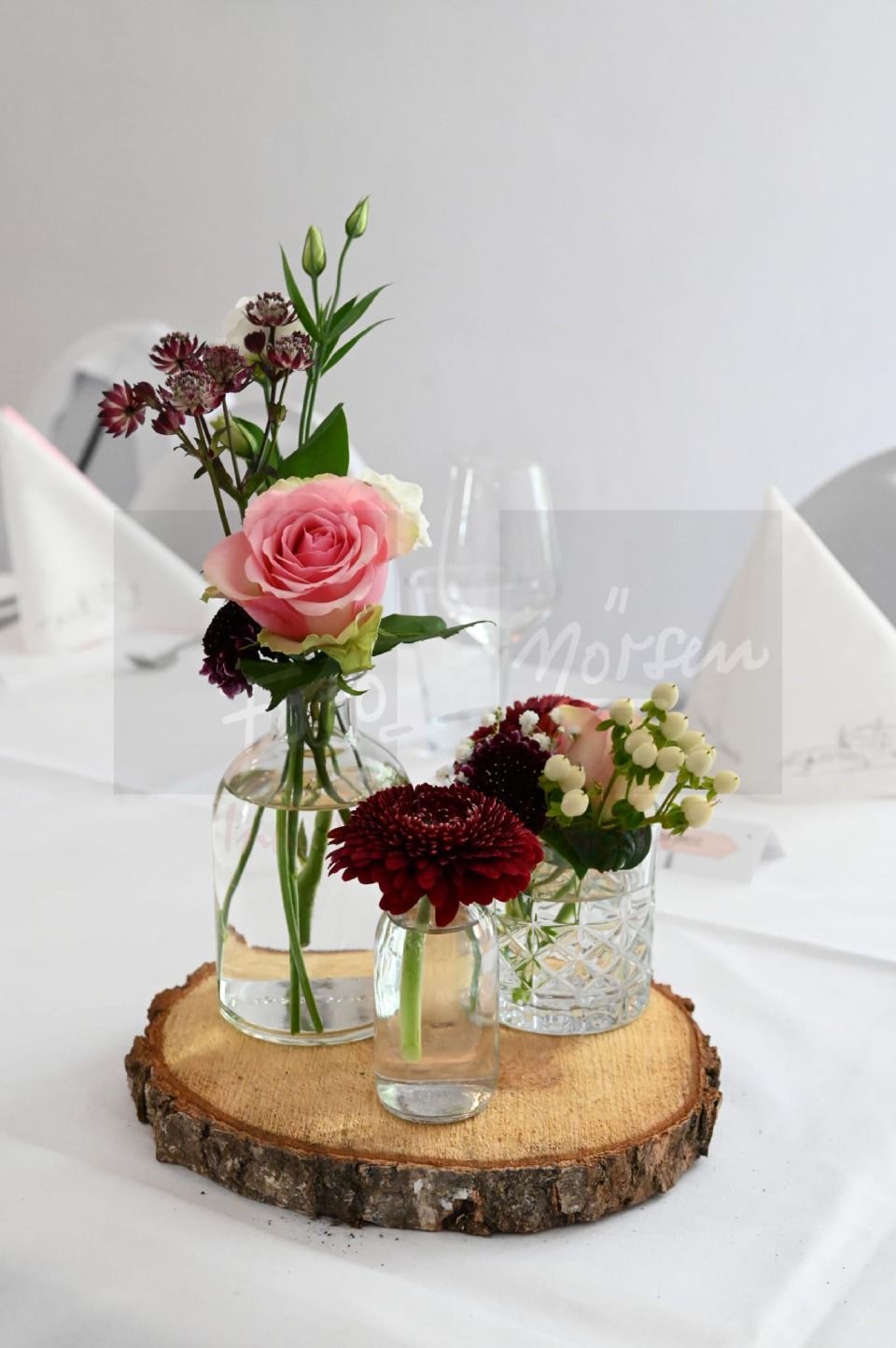 Tischdekoration mit Holzscheibe und Blumen