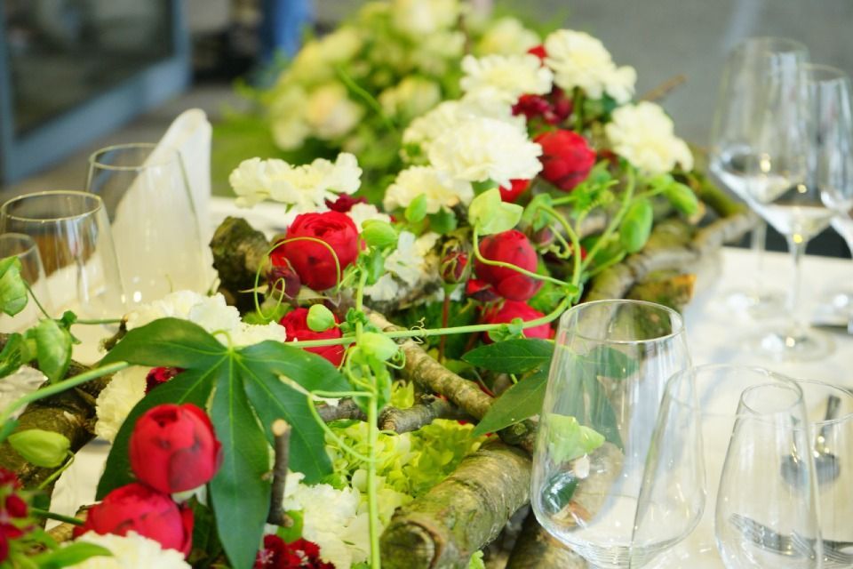 Tischdeko mit weissen und roten Blumen