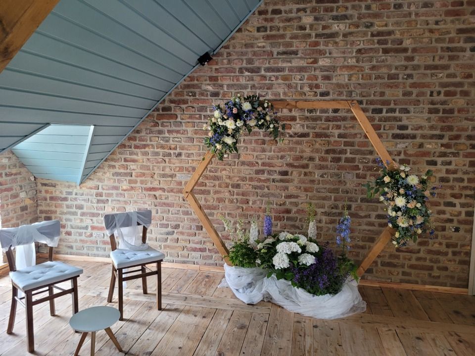 Blumendeko mit weissen Blumen vor Backsteinwand