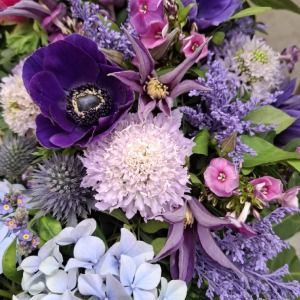 Frau mit violettem Kleid und weissem Blumenstrauss