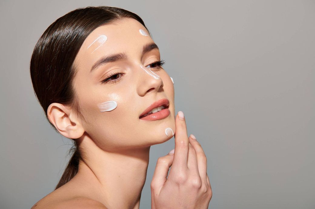 Una mujer se aplica crema en la cara.