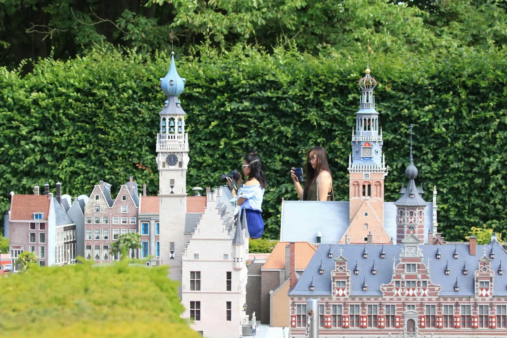 Twee mensen in oranje badjassen ontspannen op banken in een sfeervol verlichte saunaruimte.