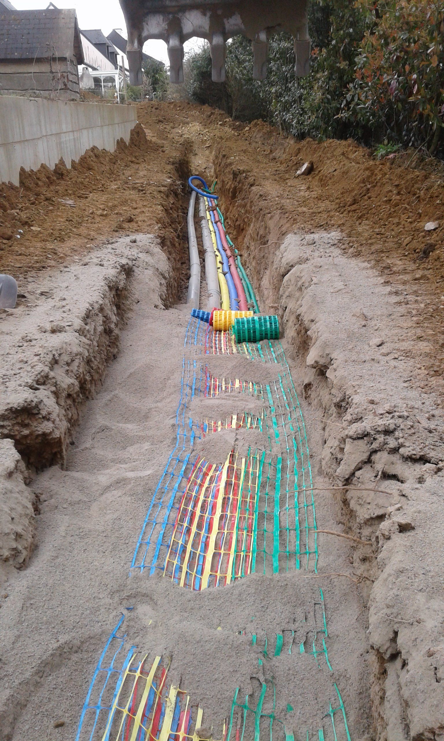 Mise en place de gaines électriques, télécoms et autres conduits dans une tranchée remblayée