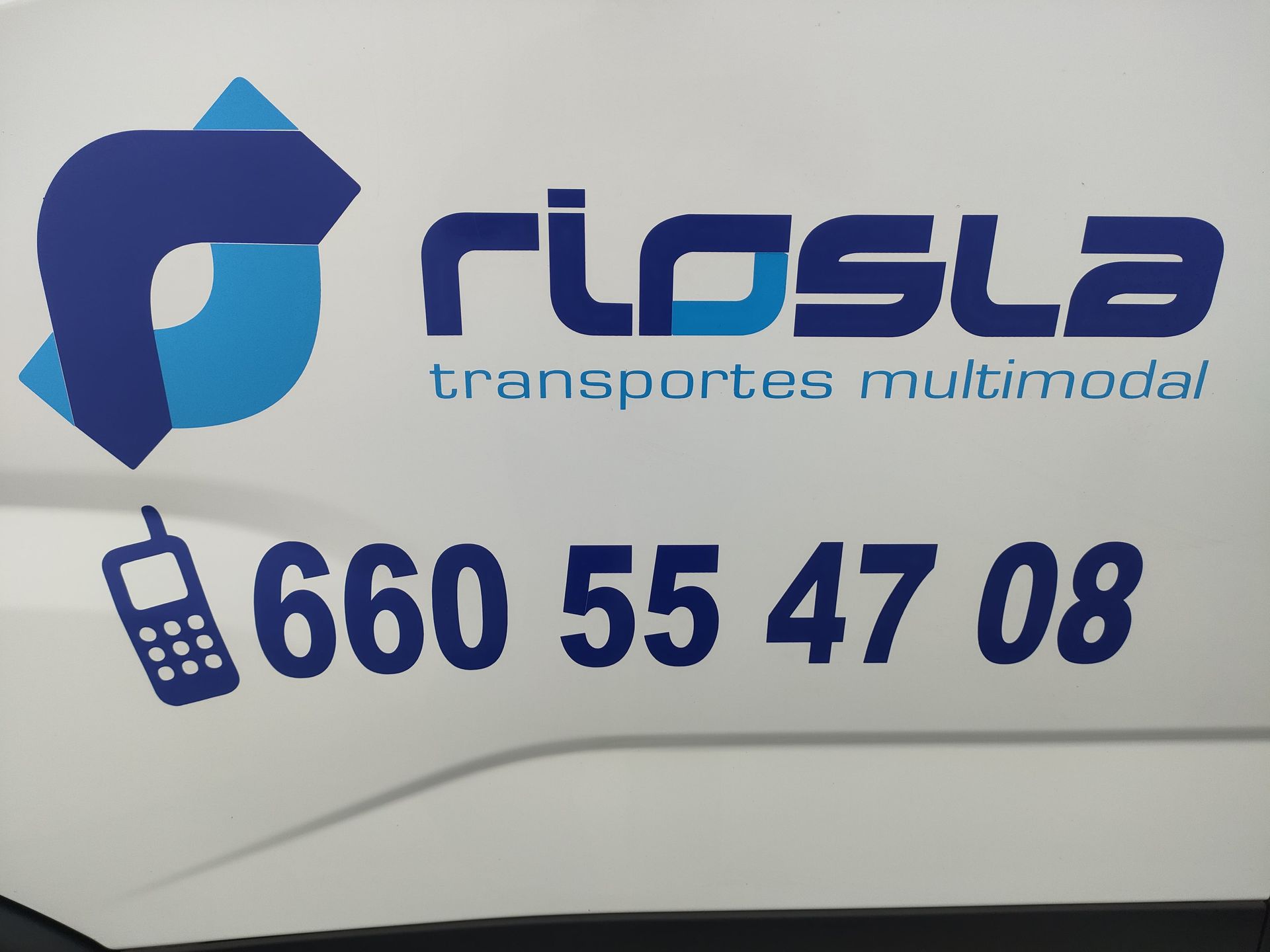 Lateral del vehículo de color blanco con logo azul y número de teléfono de 