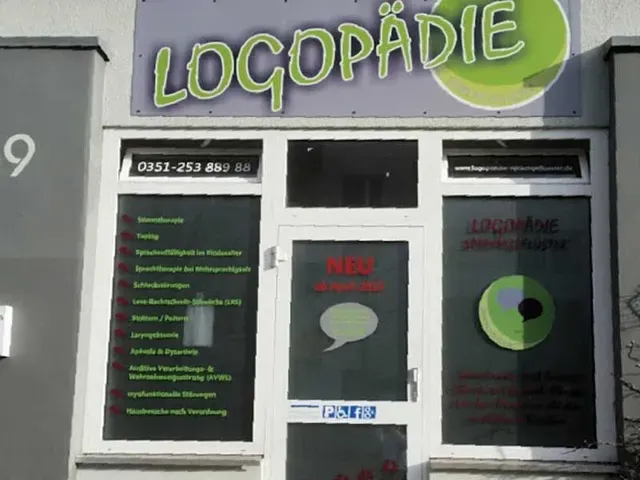 Ein Schaufenster für eine Logopädiepraxis mit Logo und Leistungsverzeichnis auf Deutsch.